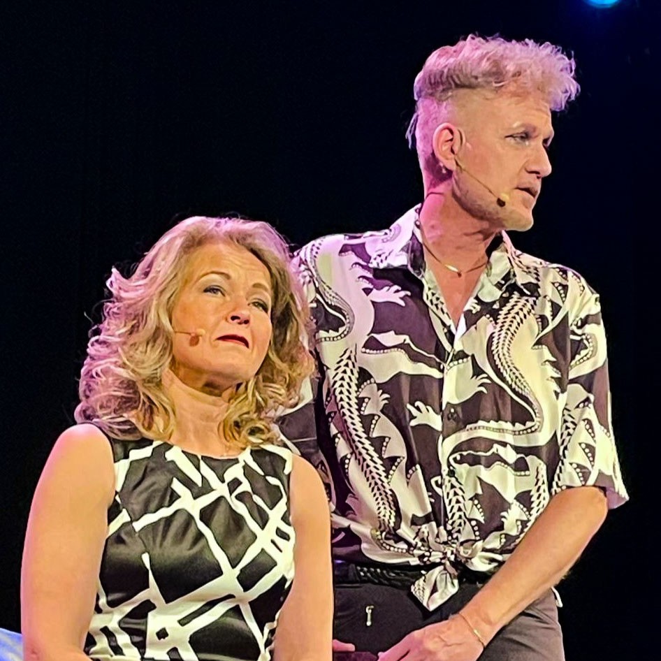 Duo van Nederlied Ensemble kijkt expressief tijdens muzikale scène op het podium.