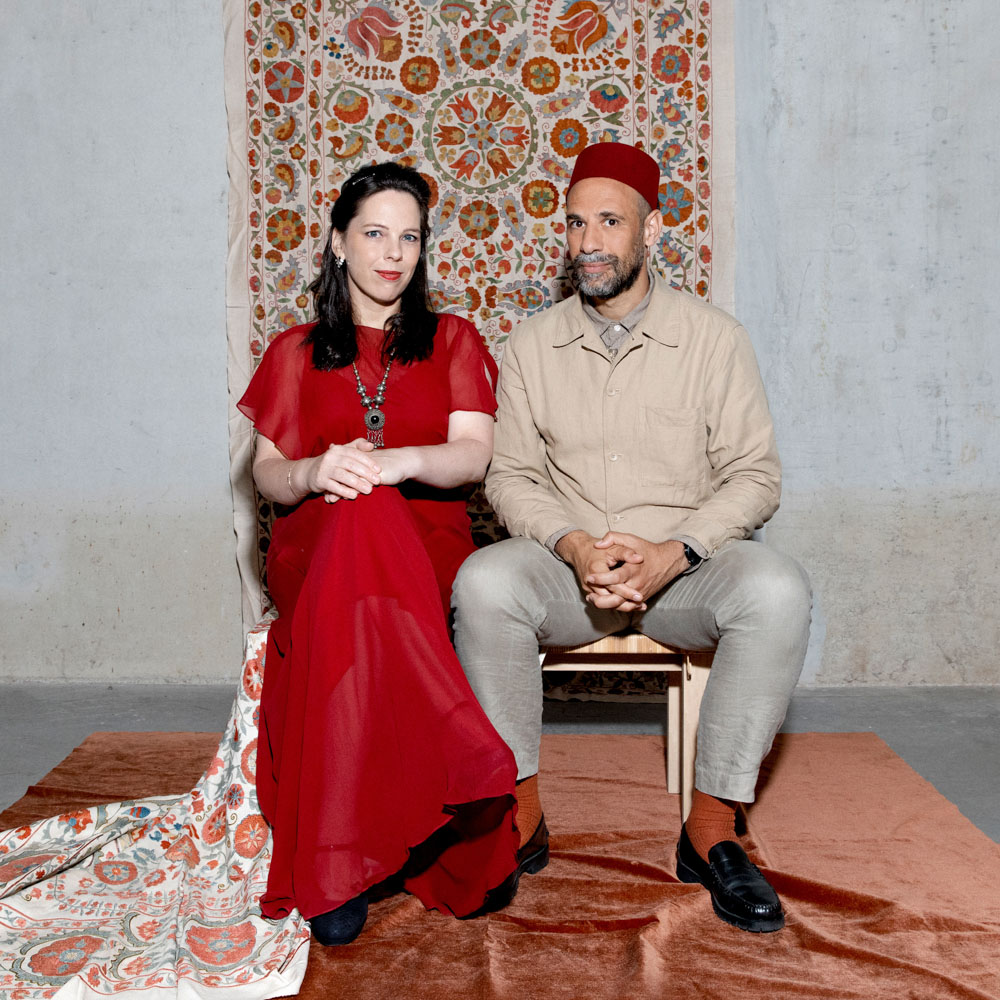 Abdelkader Benali en Daria van den Bercken zitten naast elkaar voor een oosters kleed.