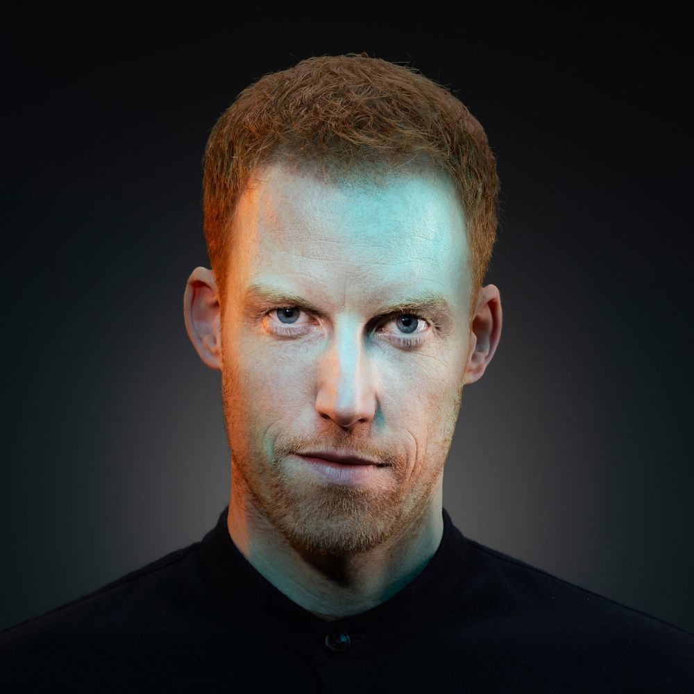 René van Meurs kijkt recht in de camera er schijnt licht op zijn gezicht.