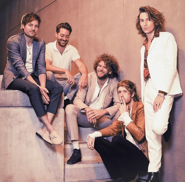 Bandleden van Stones Sessions poseren in stijlvolle pakken op een betonnen trap.