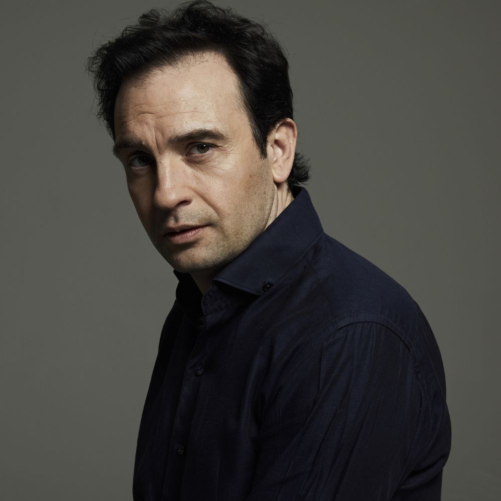 Jeroen Spitzenberger kijkt indringend in de camera tegen neutrale achtergrond.